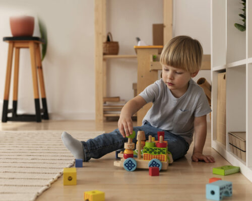 full-shot-kid-playing-with-wooden-toy-home full-shot-kid-playing-with-wooden-toy-home